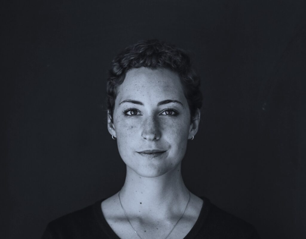 Black and white portrait of young woman with short hair looking at the camera